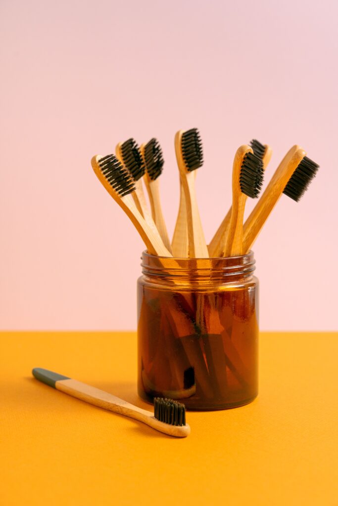 A collection of wooden toothbrushes in a jar on a warm background. Ideal for eco-friendly dental care themes.